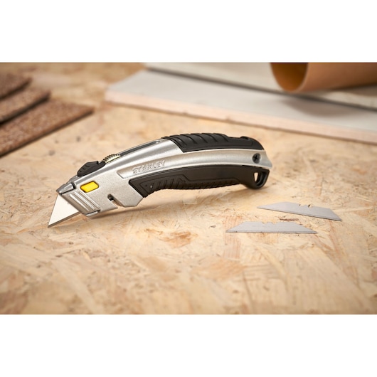 STANLEY 0-10-788 utility knife with black and silver handle shown on plywood with spare blades.