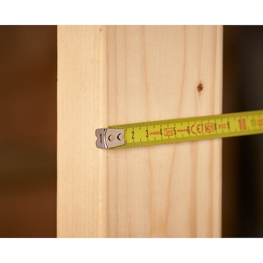 STANLEY 0-33-238 tape measure measuring a wooden plank, close-up photography.