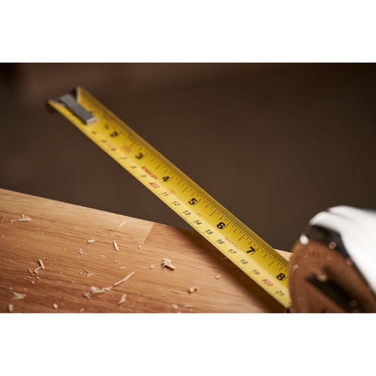 STANLEY 0-33-526 tape measure extended over wooden board with wood shavings, close-up photography.