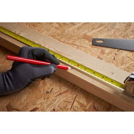 STANLEY 0-33-553 tape measure on wooden beam, hand in black glove marking with red pencil, close-up.