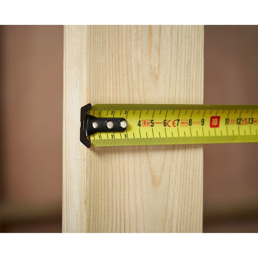 STANLEY 0-33-728 tape measure measuring wooden plank close-up.