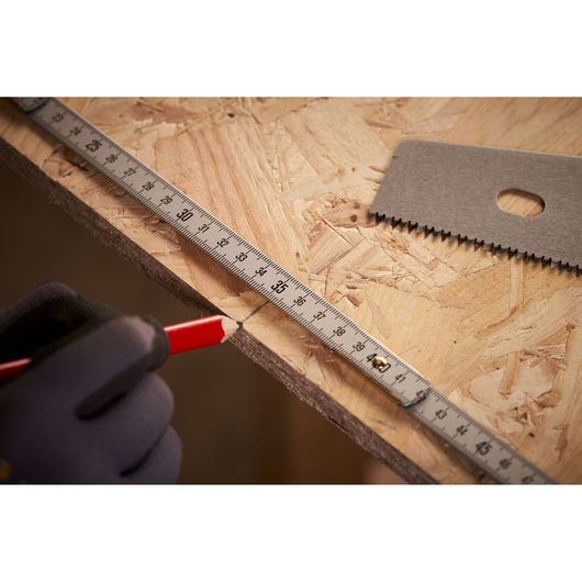 STANLEY 0-35-305 tape measure used to mark wood, close-up showing measurement and cutting tools.