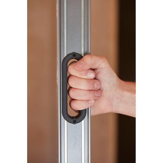 Photo of a hand holding a STANLEY 0-43-672 level tool with black ergonomic handle, close-up view.