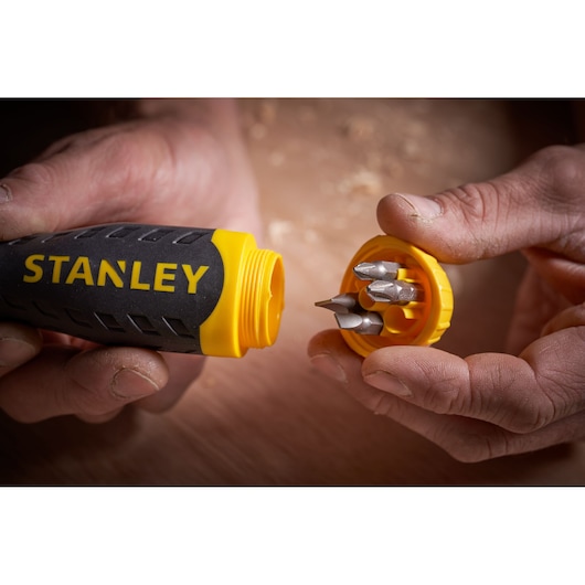 STANLEY 0-68-010 screwdriver handle with yellow cap open, showing bit storage and four bits inside, close-up.