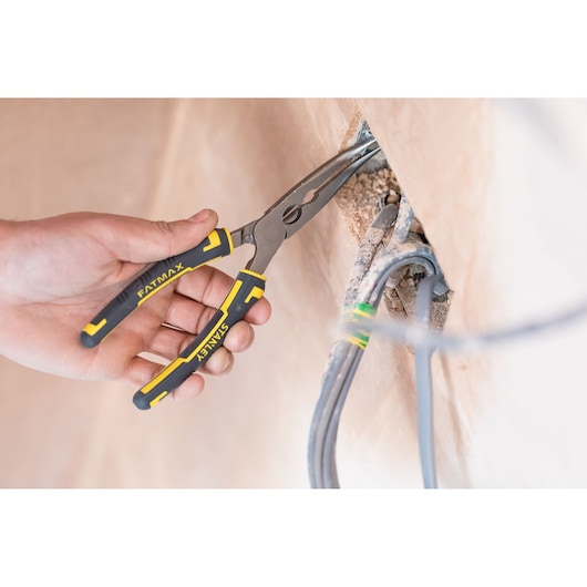 Stanley 0-89-872 FATMAX pliers used to grip electrical wires, black and yellow handles, close-up view.