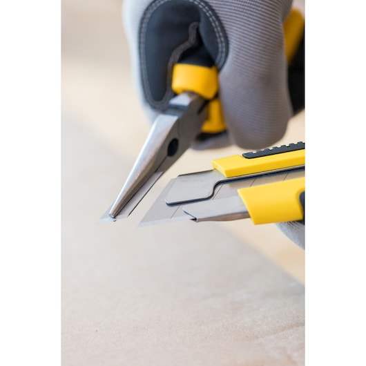 Photo of STANLEY 1-10-425 utility knives and pliers in hand, close-up on yellow and black handles.