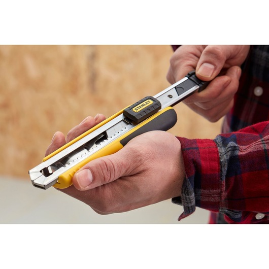 Photo of STANLEY 1-10-481 utility knife with yellow handle in use, close-up view.