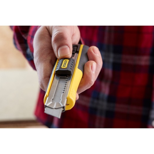 Photo of a STANLEY 1-10-481 utility knife with a yellow body and retractable blade held in hand.