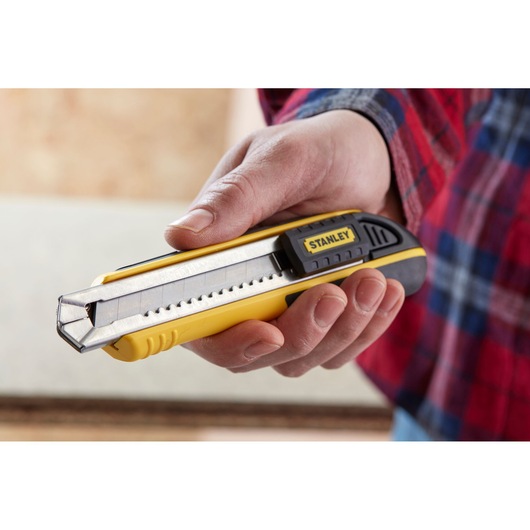 Photo of STANLEY 1-10-481 utility knife held in hand, yellow and black body with retractable segmented blade.