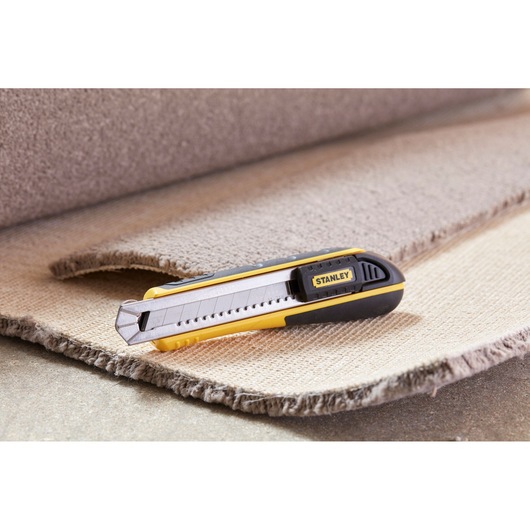 STANLEY 1-10-481 utility knife with yellow and black handle on textured carpet, side angle.