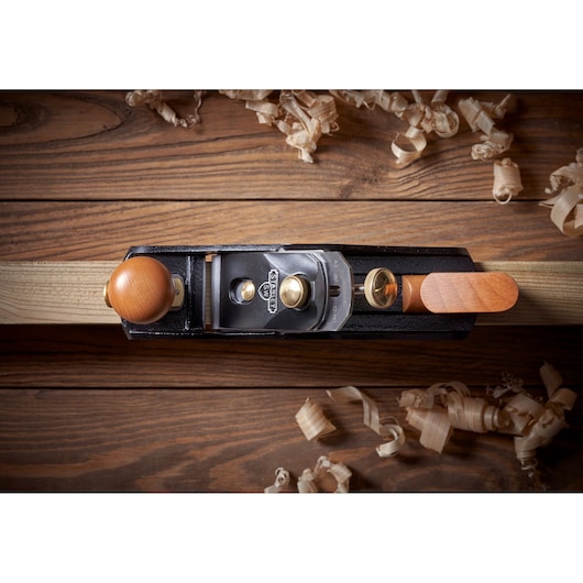 STANLEY 1-12-136 hand planer top view, wooden handle, on wood surface with shavings.