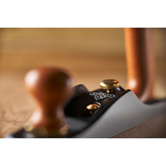 Photo of STANLEY 1-12-137 hand plane with wooden handles and metal body, close-up angle.