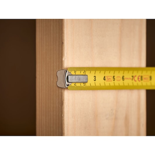 STANLEY 1-33-191 tape measure measuring wooden plank, close-up.
