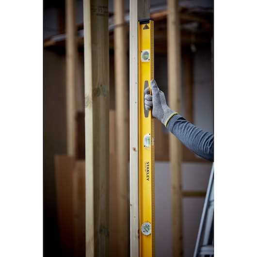 Photo of STANLEY 1-42-922 spirit level used vertically on wood frame construction.