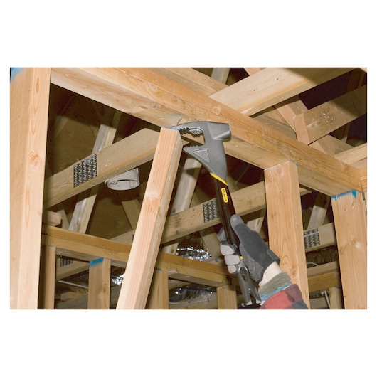 Stanley 1-55-099 adjustable wrench used on wooden framing, photography of construction context.