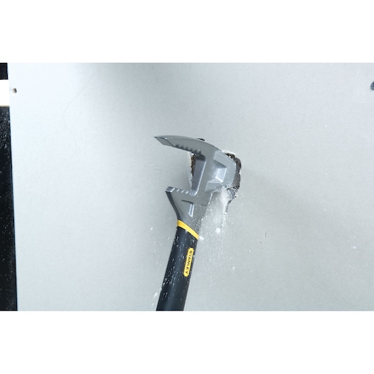STANLEY 1-55-099 demolition hammer in action breaking drywall, close-up angle, black and yellow handle.