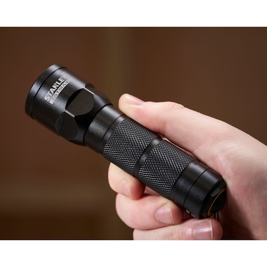 STANLEY 1-95-152 black textured flashlight held in hand, close-up side view, photography category.