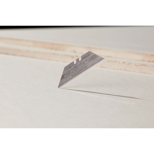 STANLEY 2-11-800 utility blade, silver color, close-up side angle on light surface.