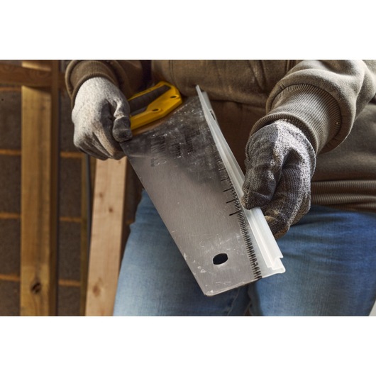 Photo of STANLEY 2-20-037 handsaw with yellow handle, blade guard, held by gloved hands.