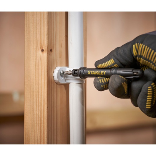 Photo of STANLEY 66-344M screwdriver securing pipe bracket to wooden post, close-up view.