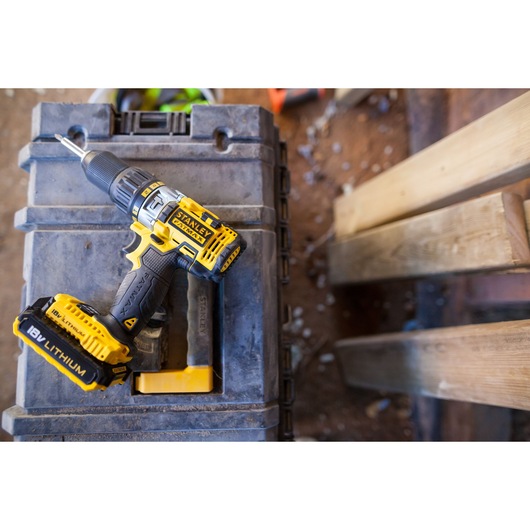 STANLEY FMC625D2 cordless drill with 18V lithium battery on a rugged toolbox, top view.