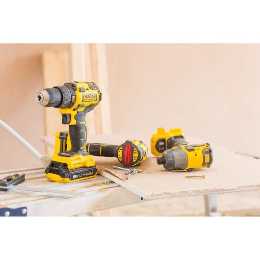 STANLEY FMC647D2 drill and impact driver set on workbench, yellow and black, photo of tools with screws.