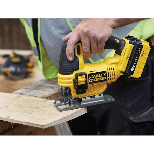 STANLEY FMC650M2 cordless jigsaw with 18V battery, cutting wood, close-up of tool in use.