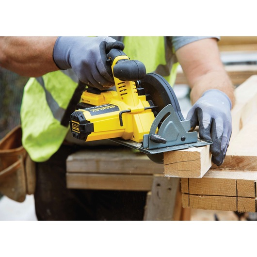STANLEY FMC660M2 cordless circular saw cutting wood plank, close-up in workshop setting.