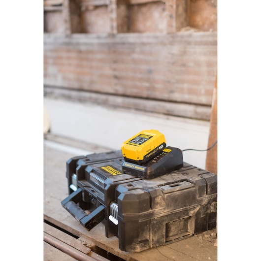 STANLEY FMC688L battery charger resting on rugged black toolbox, photo from front angle.