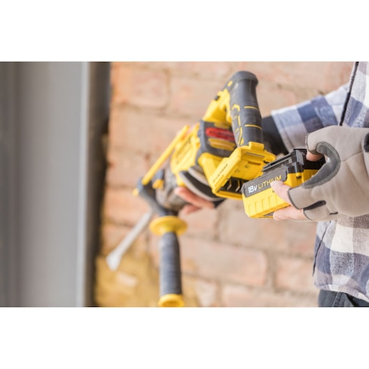 STANLEY FMCD900B cordless reciprocating saw with 18V lithium battery being inserted, close-up view.