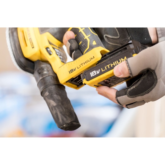 STANLEY FMCW210B cordless tool with 18V lithium battery being inserted, close-up photography.