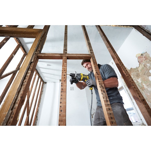 STANLEY FMEH850K drill in use on wooden framing, construction site, close-up side angle.