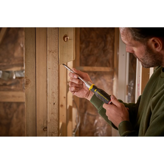 Photo of STANLEY FMHT0-62690 screwdriver used on wooden construction by person in green sweater.