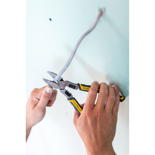 Photo of STANLEY FMHT0-75469 wire stripper pliers with yellow and black handles in use on electrical wire.