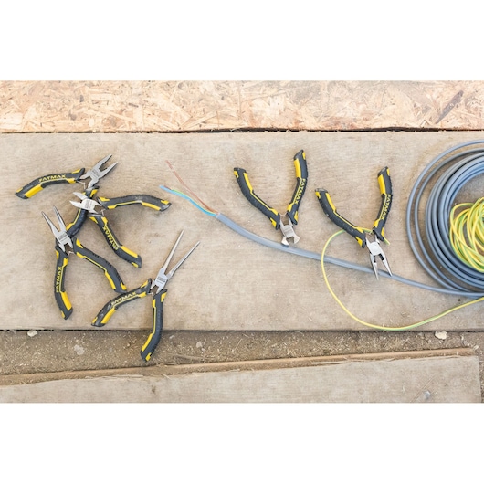 STANLEY FMHT0-80541 pliers set with black and yellow handles on a worksite, shown from above.