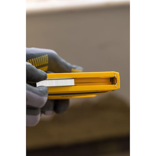 STANLEY FMHT0-80551 stapler held in hand, showing side view and staples inserted.
