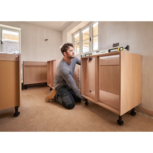 Photo of STANLEY FMHT43674-1 spirit level on cabinet frame during kitchen installation.