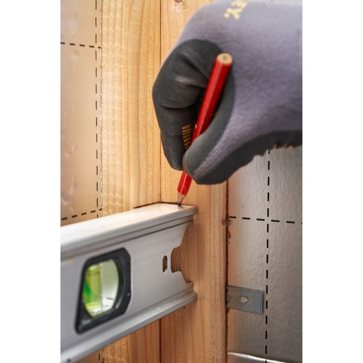 STANLEY FMHT43675-1 photography of spirit level marking wood post with pencil, close-up view.