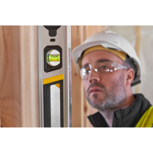 Stanley FMHT43675-1 spirit level close-up, vertical position, showing vial and yellow accent.
