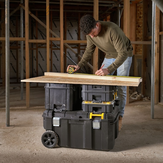 STANLEY FMST17870-1 modular rolling toolbox set stacked and used as a workbench in a construction site.