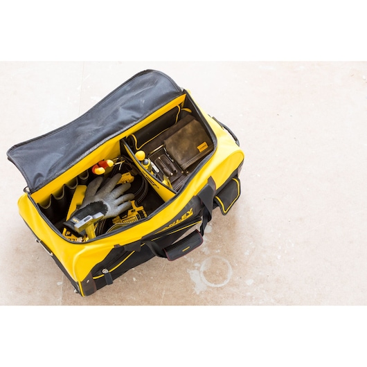 STANLEY FMST82706-1 tool bag open top view with tools, gloves, and compartments, photo on light floor.