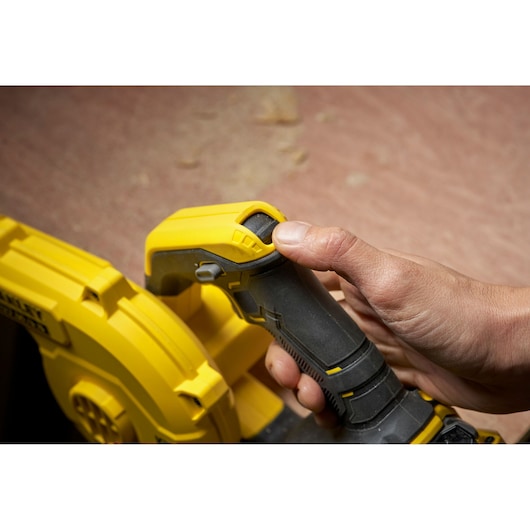 STANLEY SFMCBL01B blower handle close-up with hand operating power button, side angle.