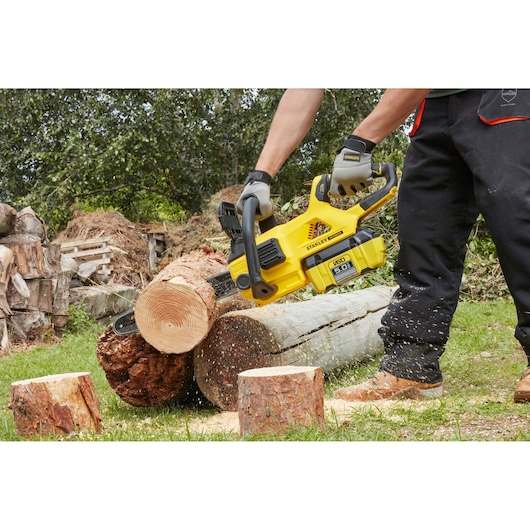 STANLEY SFMCCSB664B chainsaw cutting log outdoors, close-up action shot.