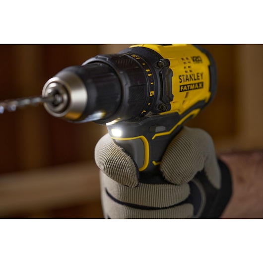 Photo of STANLEY SFMCD710C2K cordless drill in use, yellow and black body, close-up side angle.