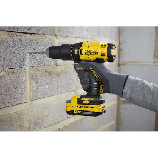 Photo of STANLEY SFMCD711C2S V20 cordless drill being used on a brick wall.