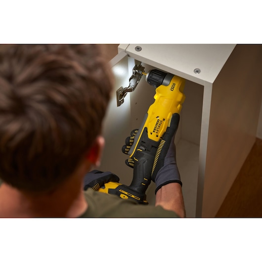 STANLEY SFMCD750D2K cordless drill used on cabinet hinge, photography showing ergonomic grip.
