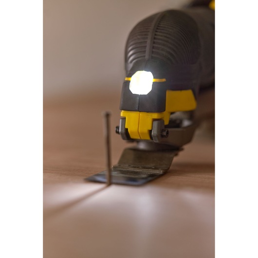 STANLEY SFMCE500D2K oscillating tool with LED light, close-up on blade and nail, front angle.
