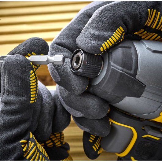 STANLEY SFMCF800C2K impact driver close-up with gloved hands inserting a bit, power tool photography.