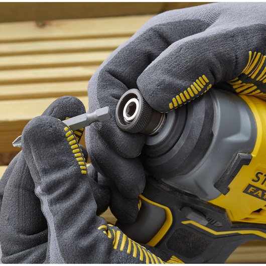 STANLEY SFMCF810D2K impact driver close-up, gloved hand inserting bit