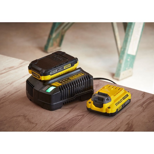 STANLEY SFMCF810D2K battery charger and battery pack set on wood surface, photo from side angle.